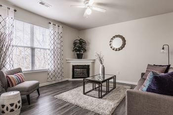 A living room with a grey couch, a coffee table, and a fireplace.